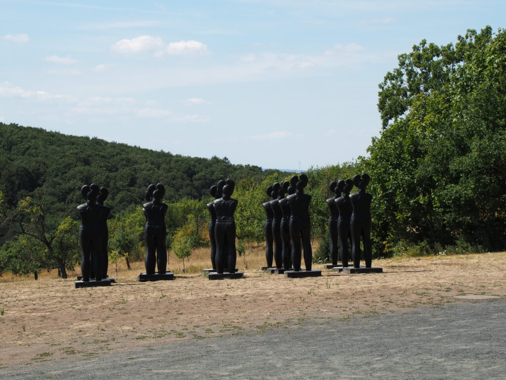 Keltenfiguren auf dem Glauberg. In mehreren Reihen stehen menschlich aussehende Figuren.
